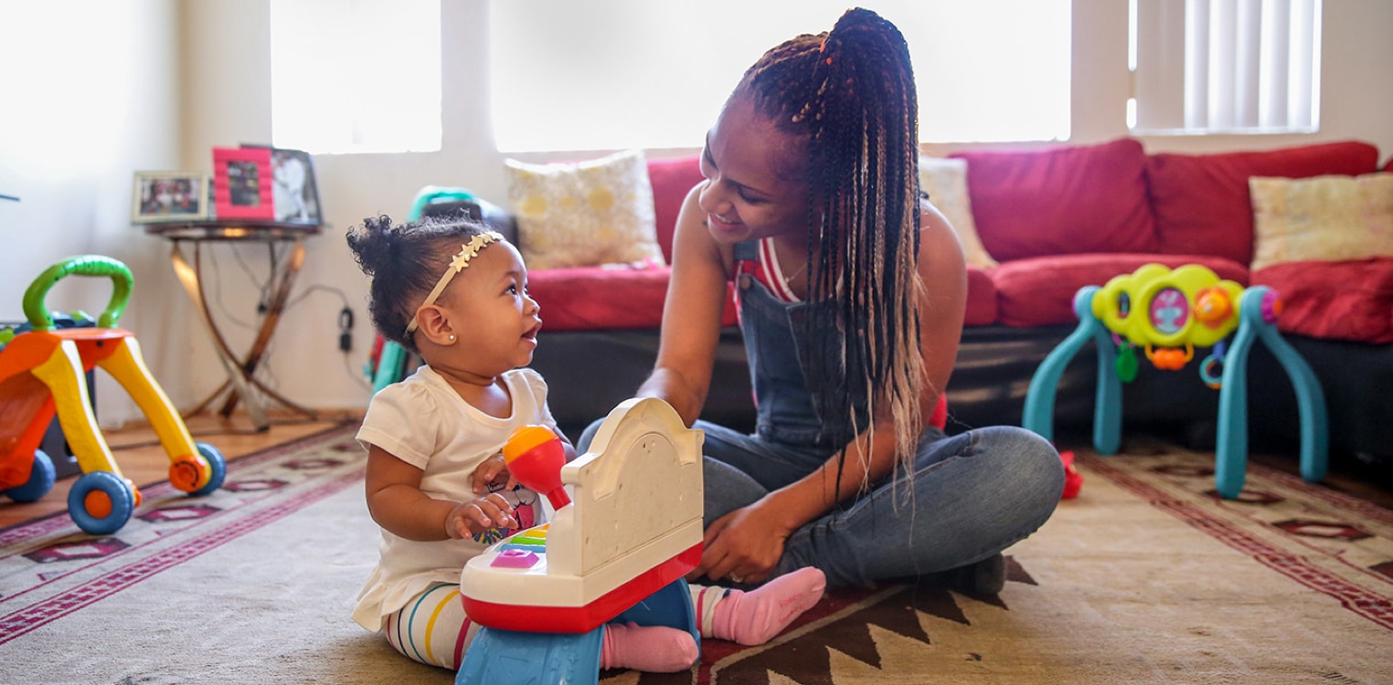 A smiling mother and her daughter playing