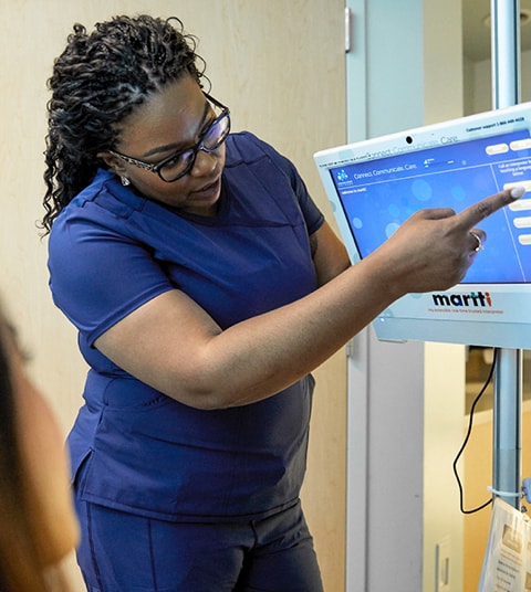 Enfermera de color señalando a la pantalla de una máquina de interpretación