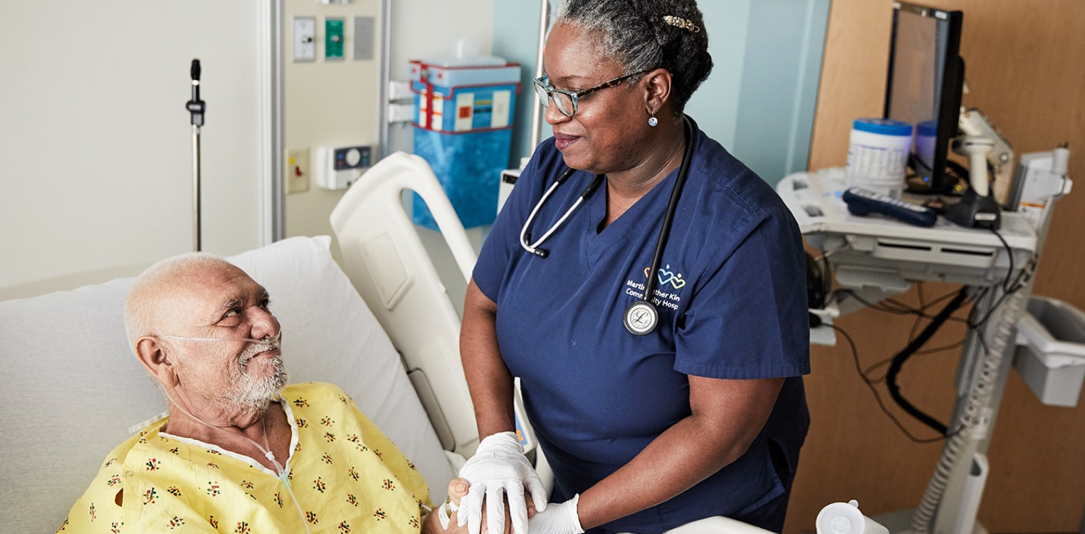 Nurse talking to man in hospital bed