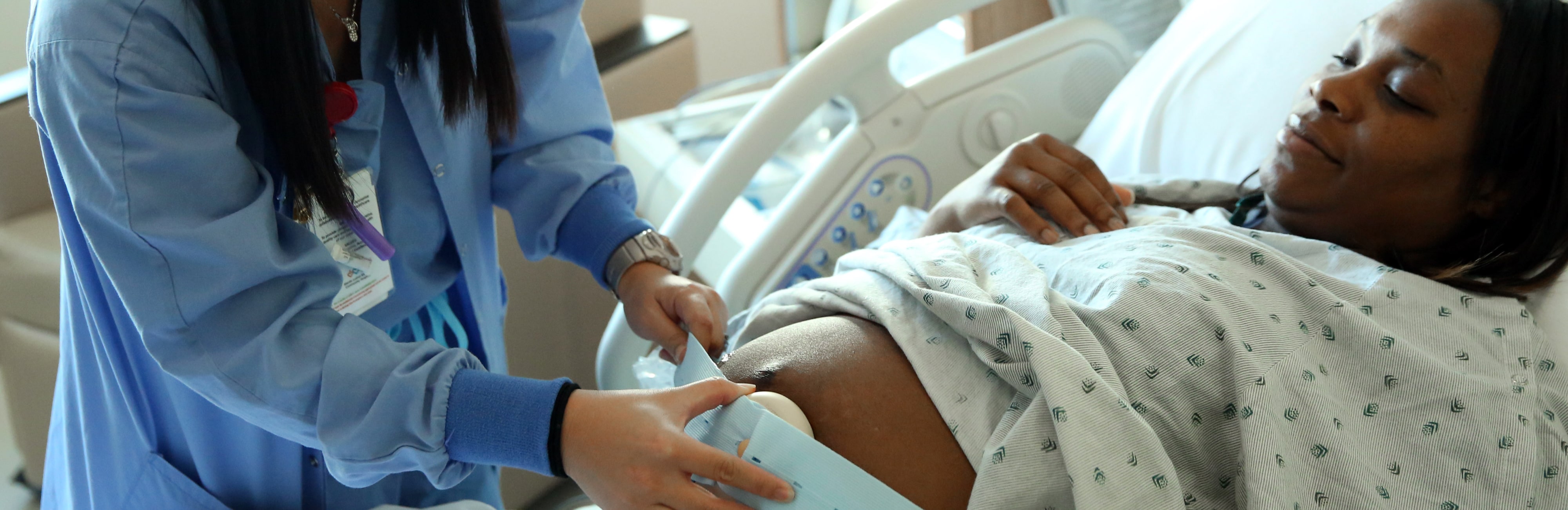 A nurse puts a fetal monitor on a pregnant mother’s belly