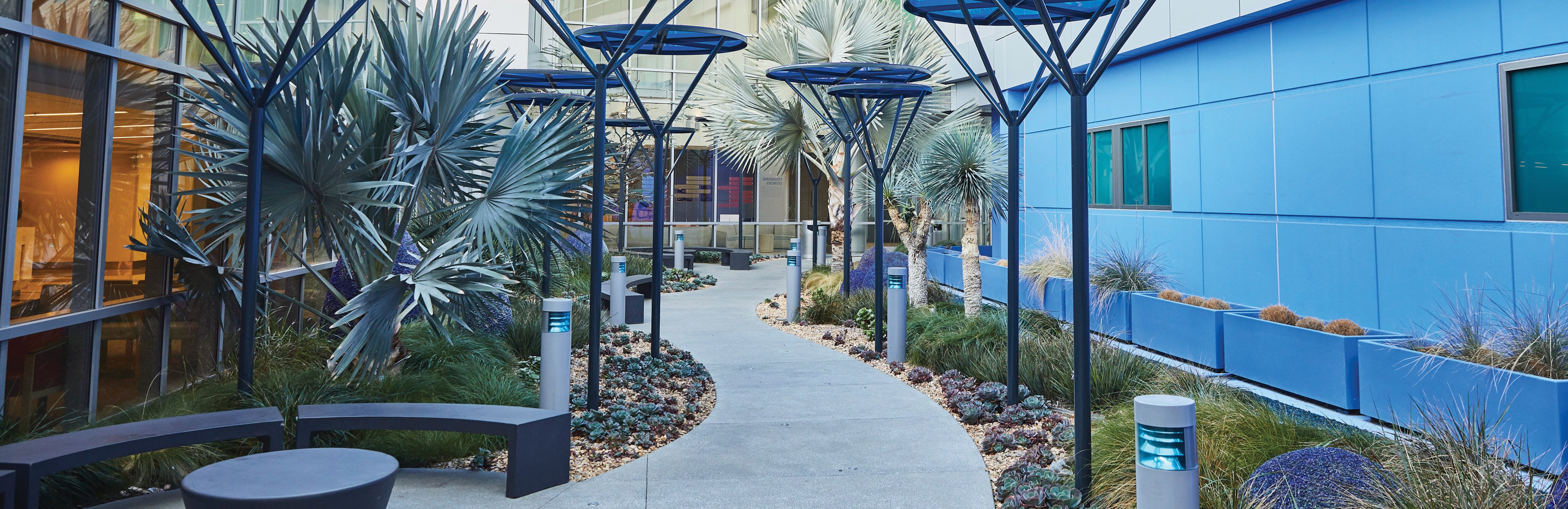Tall blue shade coverings line the walkway of the hospital's healing garden 