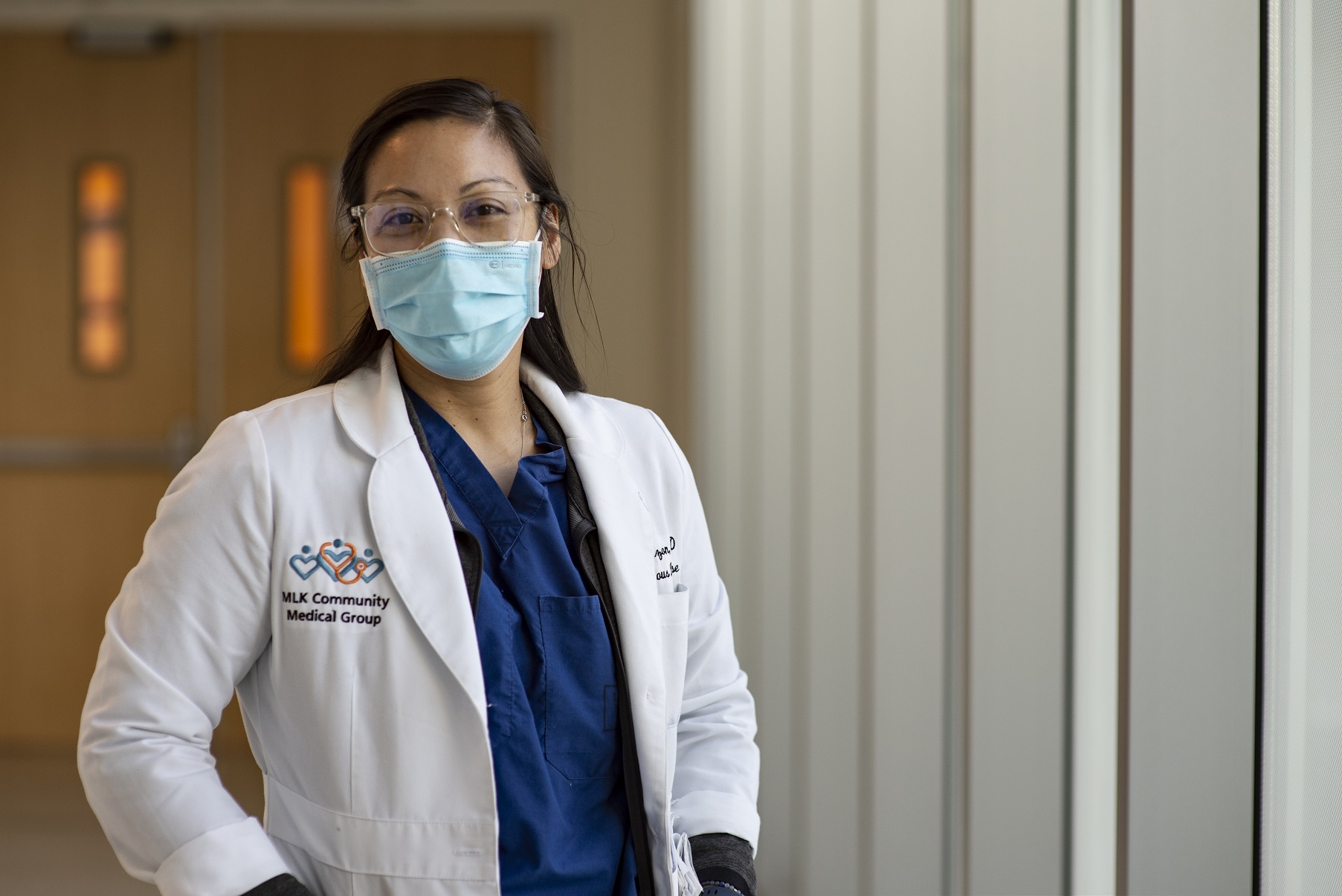 La Dra. Erin Dizon, una médica joven asiática con una bata blanca