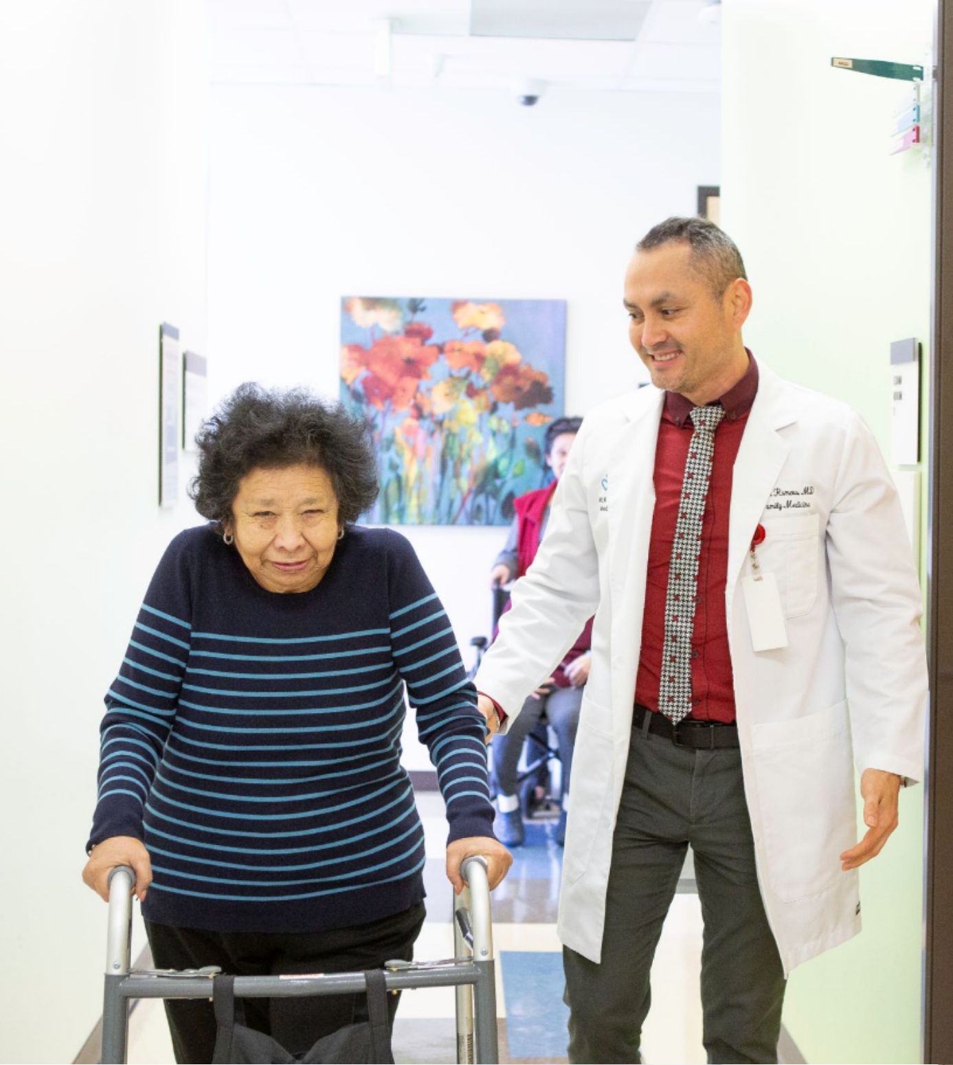 Foto de la Dra. Romero con un paciente que usa un andador