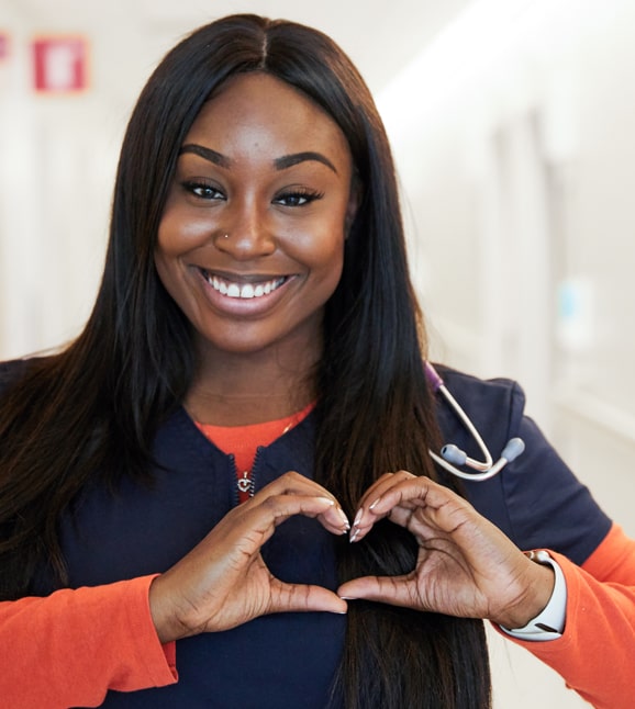 Una enfermera de color haciendo un corazón con las manos