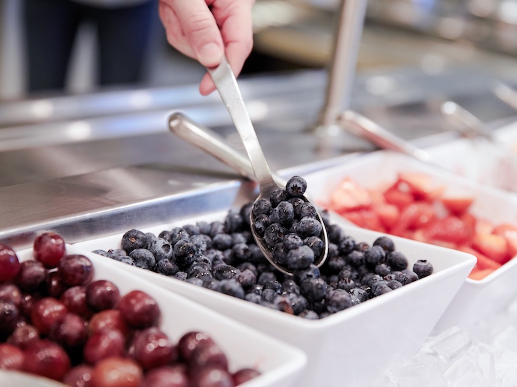 Close up of blueberries being scooped at a fruit bar