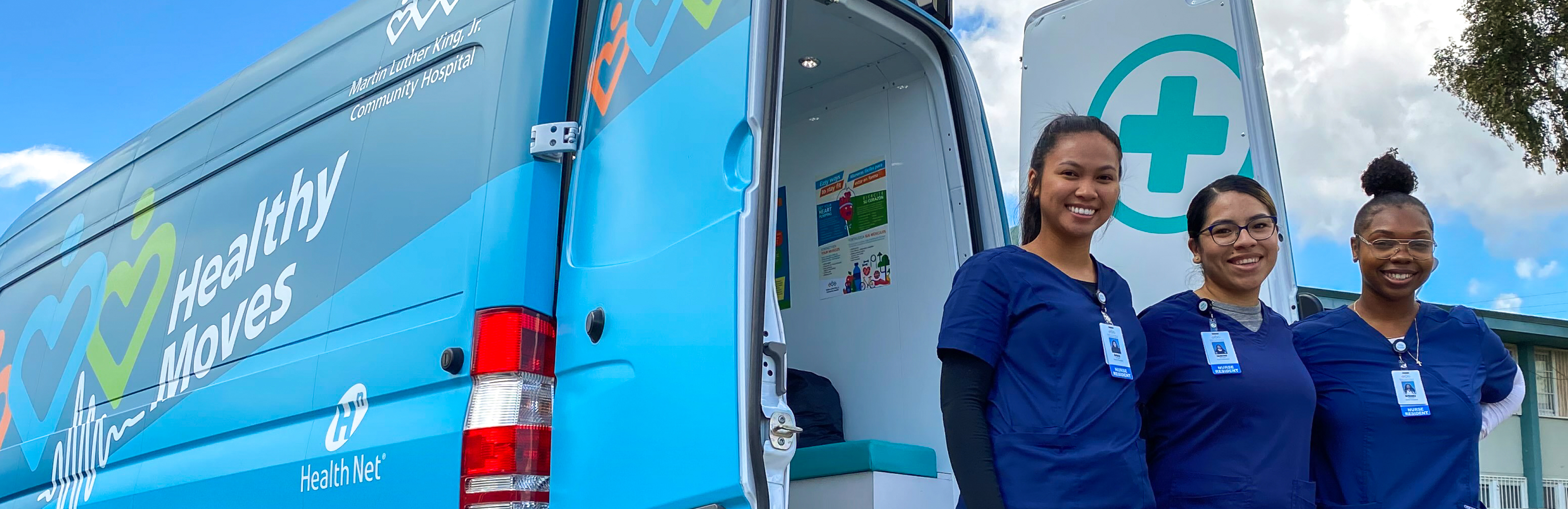 Tres enfermeras jóvenes de diferentes etnias usando uniformes azules paradas al lado de la camioneta de Healthy Moves
