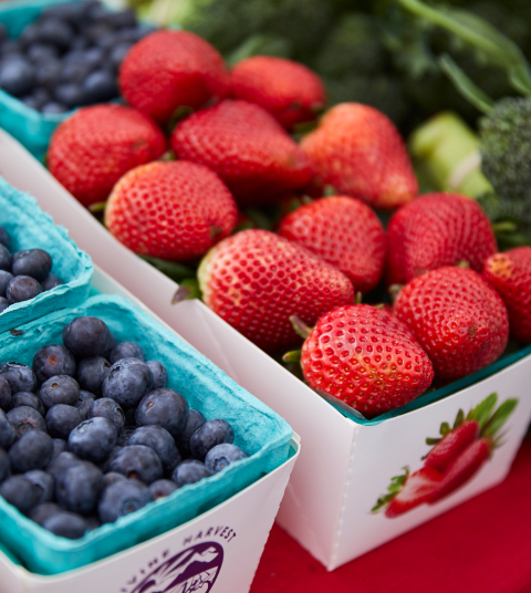 Close up of strawberries and blueberries at a farmers market