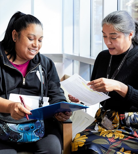 Paciente latina completando formularios con una administradora latina del hospital