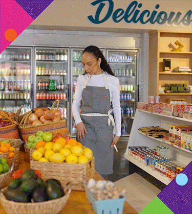 Photo of Kelli standing in Hank's Mini Market next to produce