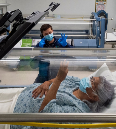 Photo of patient inside a hyperbaric chamber and chamber technician
