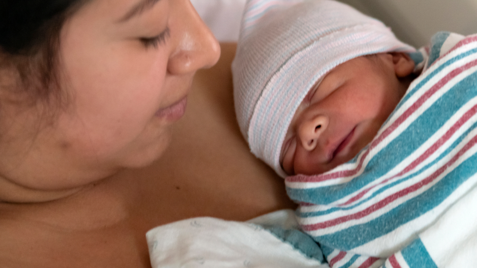 Foto en primer plano de una madre sosteniendo a su bebé recién nacido