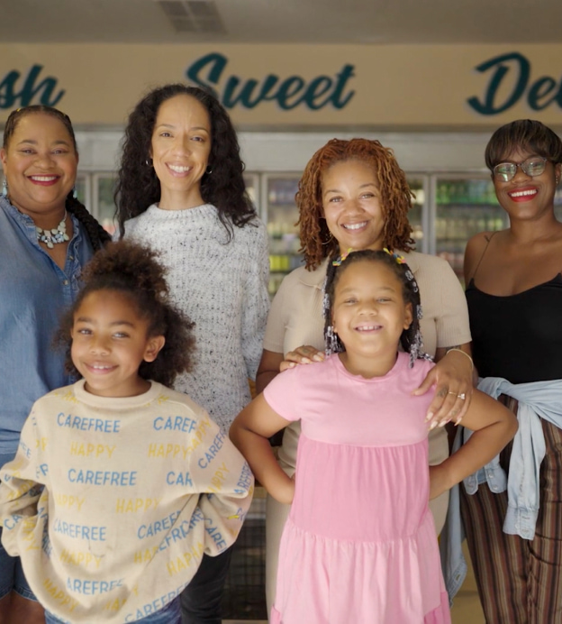 Kelly and community members standing in Hank's Mini Market