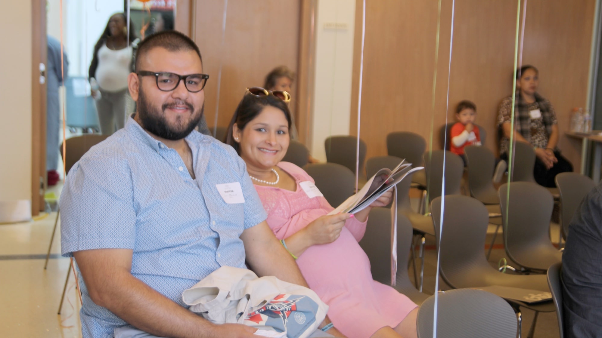 Smiling Latinx couple at maternity event