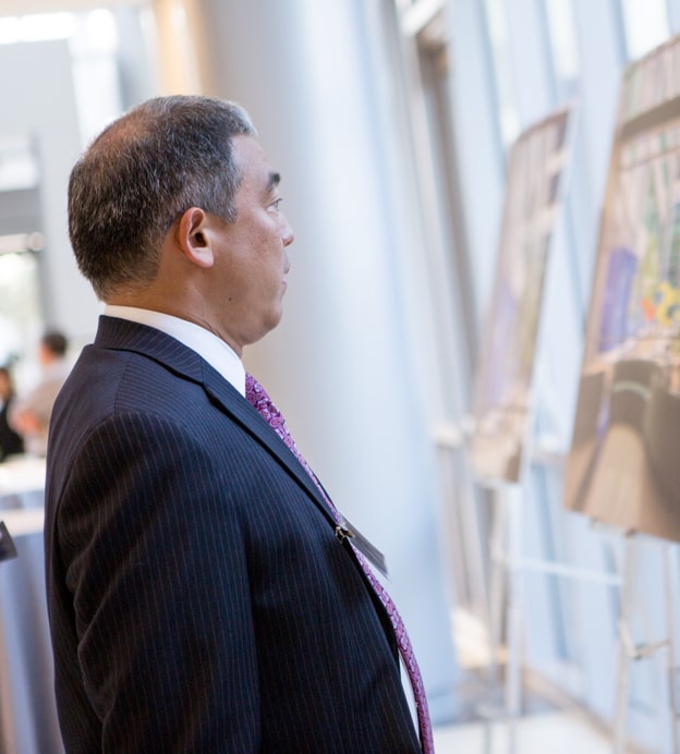 Middle-aged man in profile looks at photos of hospital