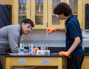 image of high school student with chemistry equipment