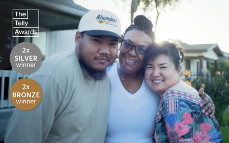 Dr. Monica Banks and her family hugging in front of their home