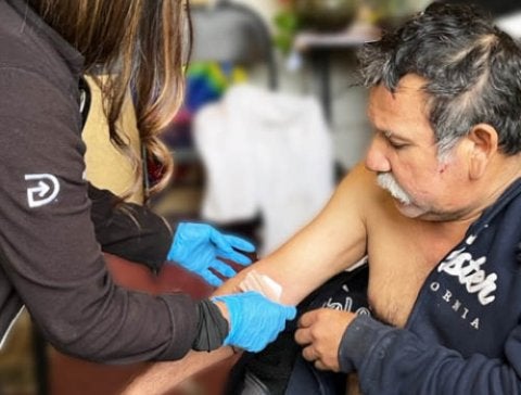 a man getting a bandage out on his arm
