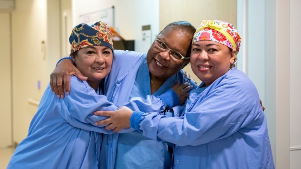 Photo of three nurses hugging