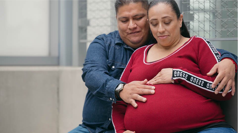 Husband holding wife's pregnant belly