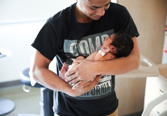 Young father cradling newborn baby