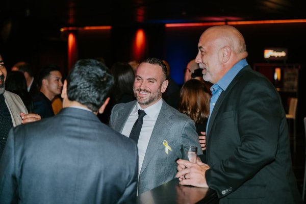 man smiling talking to a group of people