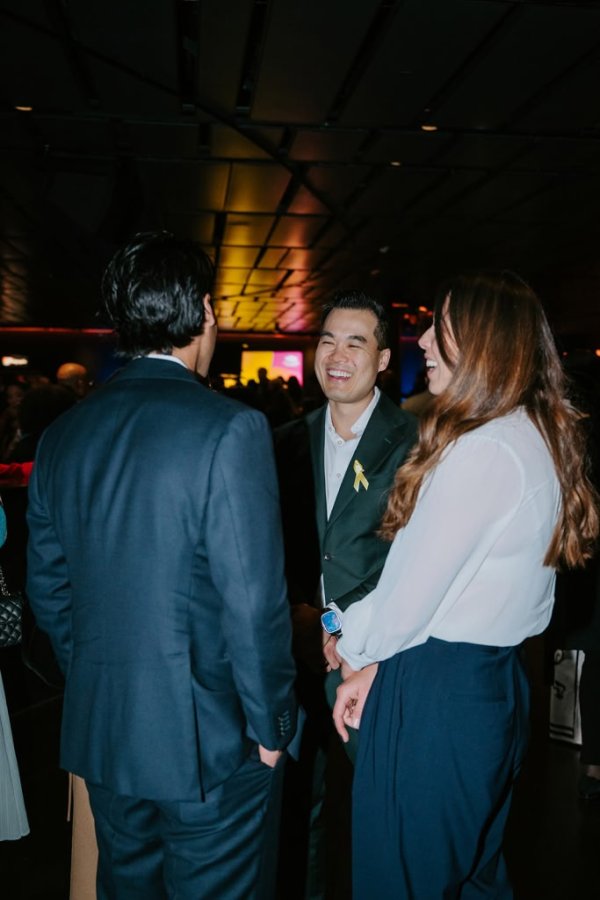man smiling talking to two people