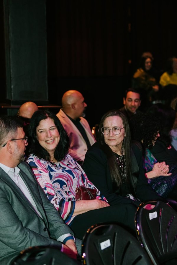group of people smiling in theatre seats