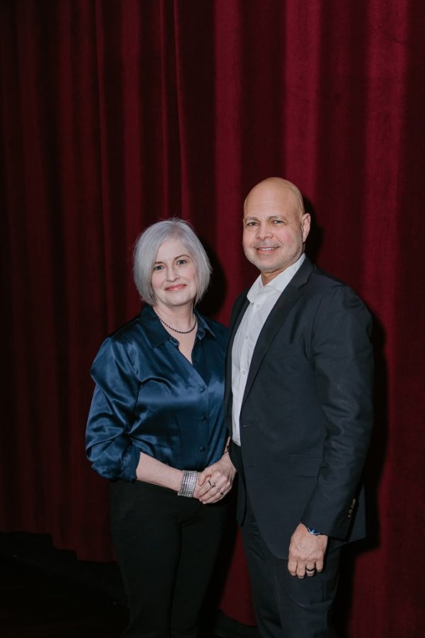 man and woman standing and smiling for a photo