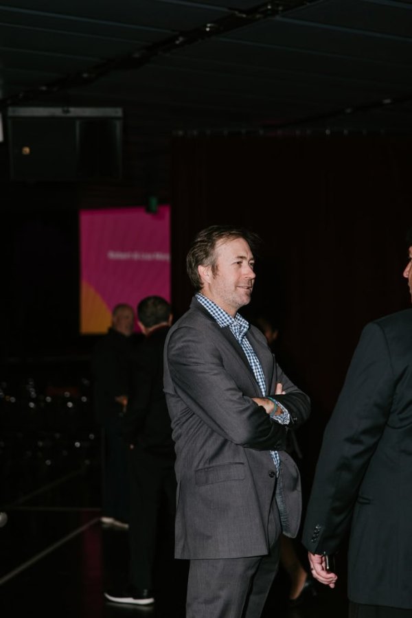 man smiling in front of theatre screen