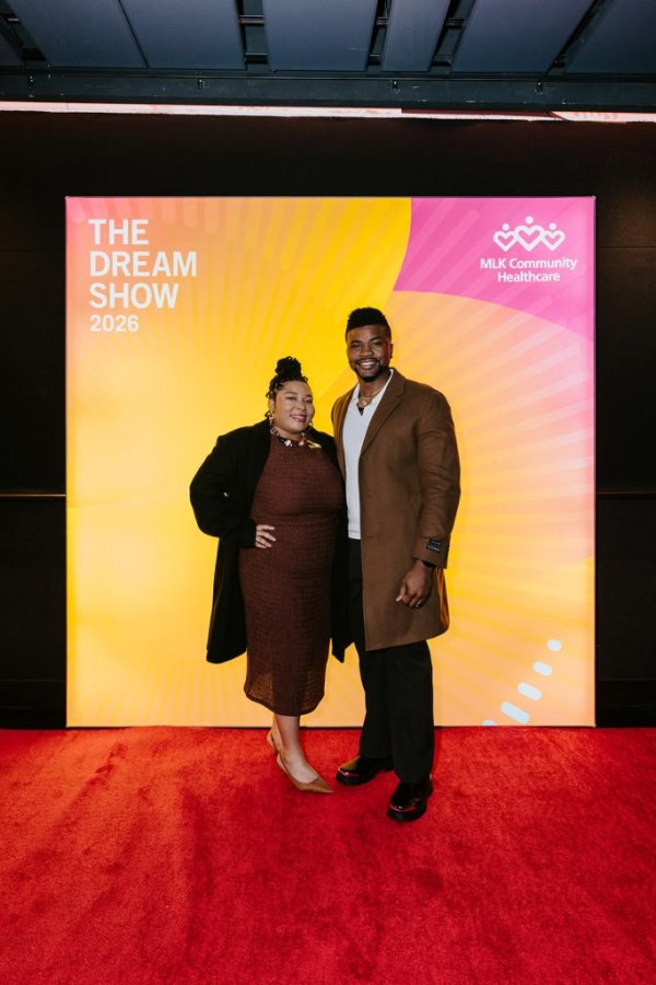 man and woman smiling in front of photo backdrop