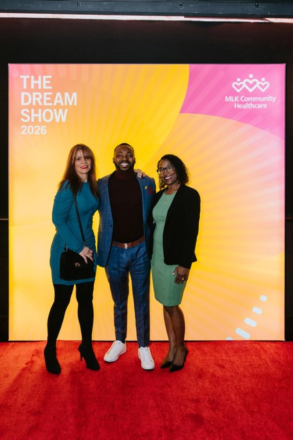 group of people smiling in front of photo backdrop