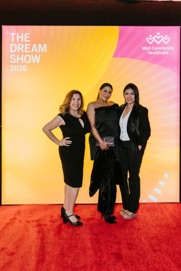 group of women smiling in front of photo backdrop