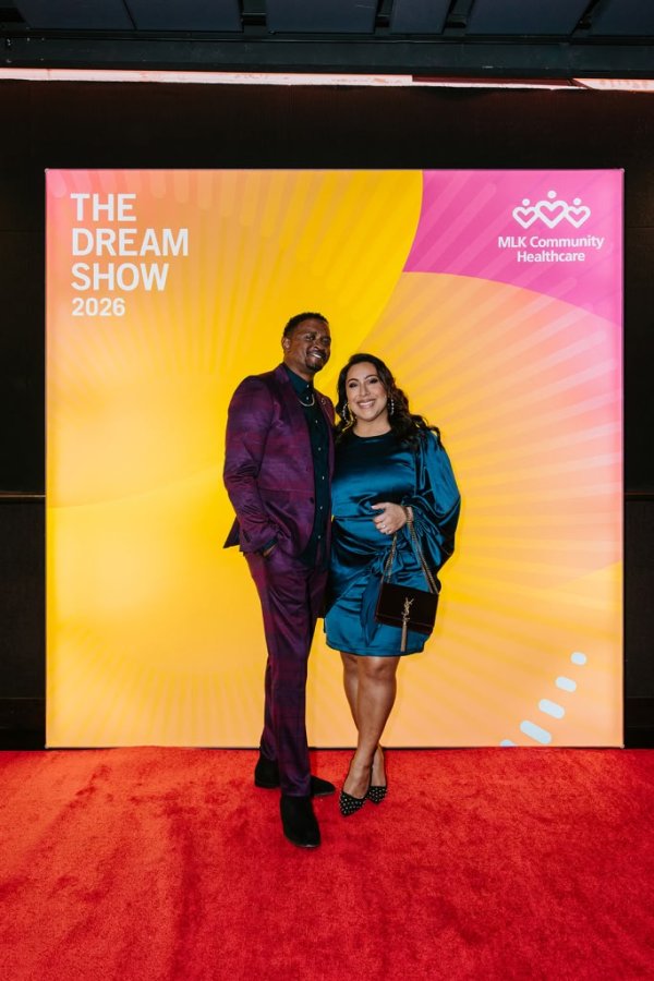 man and woman smiling in front of photo backdrop