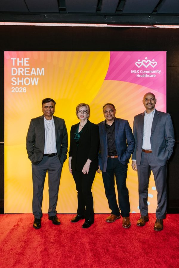 group of people smiling in front of photo backdrop