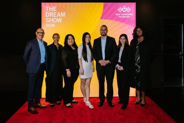 group of people smiling in front of photo backdrop
