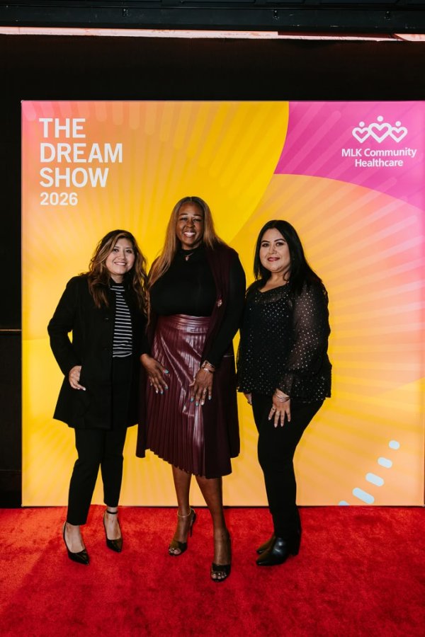 group of women smiling in front of photo backdrop