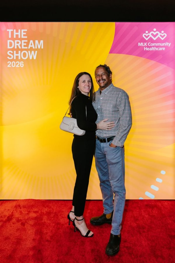 man and woman smiling in front of photo backdrop