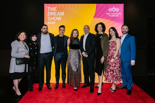 group of people smiling in front of photo backdrop