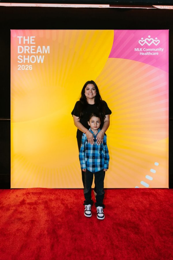 mom and son smiling in front of photo backdrop