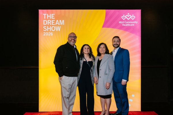 group of people smiling in front of photo backdrop