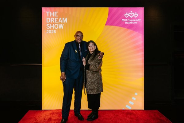 man and woman smiling in front of photo backdrop
