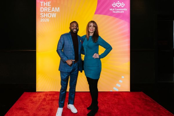 man and woman smiling in front of photo backdrop