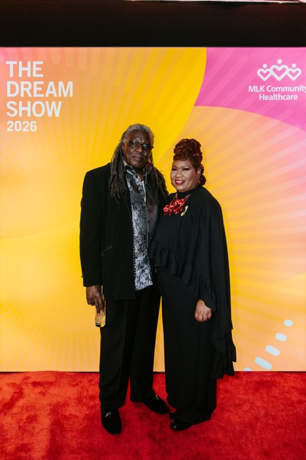 man and woman smiling in front of photo backdrop