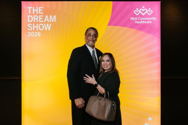 man and woman smiling in front of photo backdrop