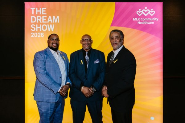 group of men smiling in front of photo backdrop