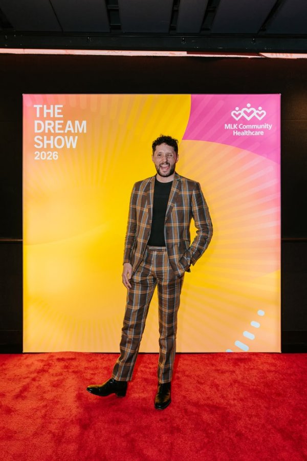 man smiling in front of photo backdrop