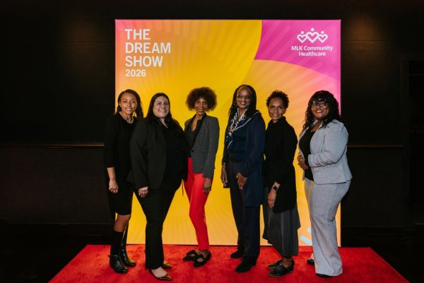 group of women smiling in front of photo backdrop