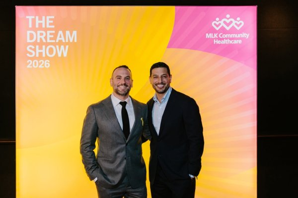 2 men smiling in front of photo backdrop