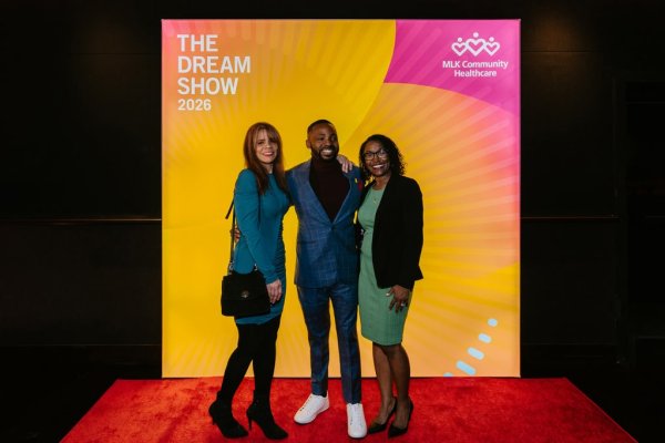 group of people smiling in front of photo backdrop