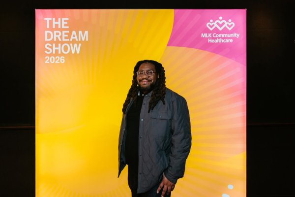 man smiling in front of photo backdrop